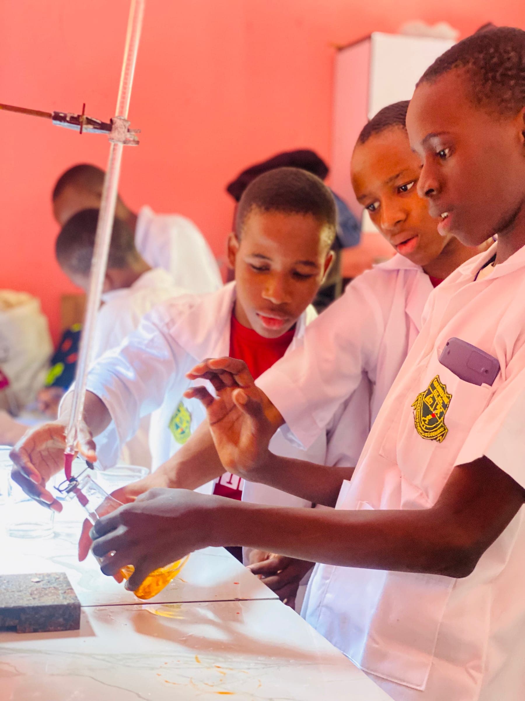 Three secondary students working together at a laboratory bench during a practical lesson